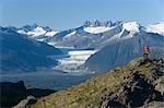 Man hiking in Alaska's Tongass National Forest with view of Mendenhall Glacier near Juneau Alaska southeast Autumn