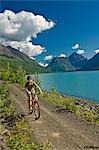 Teenage boy riding his mountain bike on the Eklutna Lake bike trail during Summer in Southcentral Alaska