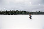 Femelle de bicyclette sur un lac gelé en hiver hiver Ely Minnesota