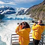 Tourist paar auf Klondike Express Glacier Cruise Tour anzeigen Treppe Gletscher (R) fließt Überraschung Gletscher Harriman Fjord, Alaska