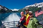 Tourists on the back deck of the Klondike Express tour boat as it leaves port in Whittier, Prince William Sound, Alaska