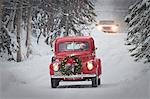 Man driving a vintage 1941 Ford pickup with a Christmas wreath on the front during Winter in Southcentral, Alaska