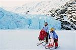 Family kick sledding together on Portage Lake Southcentral Alaska Winter Portage Valley