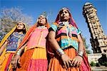 Trois femmes debout près d'un fort, Vijay Stambha Chittorgarh Fort, Chittorgarh, Rajasthan, Inde