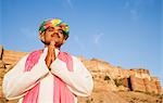 Mann im Gebet Position mit Festung im Hintergrund, Meherangarh Fort, Jodhpur, Rajasthan, Indien