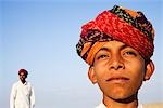 Junge mit junge Mann im Hintergrund, Jaisalmer, Rajasthan, Indien