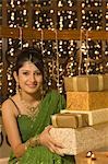 Woman holding Diwali gifts and smiling