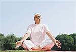 Woman practicing yoga in a park, New Delhi, India