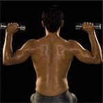 Rear view of a man exercising with dumbbells