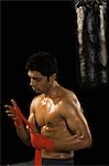 Male boxer wrapping crepe bandage on his hand