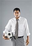 Businessman holding a soccer ball and smiling