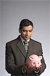 Businessman holding a piggy bank