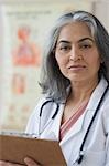 Portrait of a female doctor holding a clipboard, Gurgaon, Haryana, India