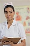 Female nurse writing on a clipboard, Gurgaon, Haryana, India