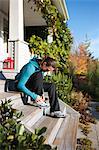 Woman Tying Shoes on Front Porch, Seattle, Washington, USA