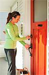 Woman with Groceries Unlocking Front Door, Seattle, Washington, USA