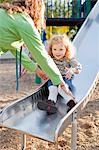 Mother Catching Daughter on Slide in Green Lake Park in Autumn, Seattle, Washington, USA