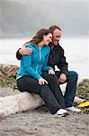 Couple Sittingon Log at Puget Sound in Discovery Park, Seattle, Washington, USA