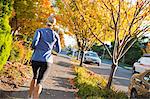 Femme en cours d'exécution sur le trottoir à l'automne, Seattle, Washington, USA