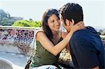 Jeune couple assis sur un banc de pierre, portrait