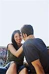 Young couple sitting on stone bench, portrait