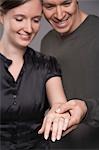 Couple regardant la bague de fiançailles sur des mains de femme