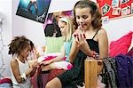 Fashionable Young Girls Applying Makeup in trendy bedroom