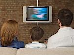 Garçon entre Parents de regarder la télévision