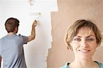 Femme souriant tout en roller homme peint mur intérieur