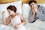 Couple with Colds Lying in Bed, high angle view