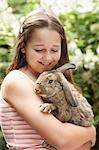 Mädchen im Hinterhof halten Hase Kaninchen
