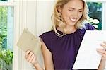 Woman looking at letter, looking happy