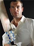 Cricket player holding cricket bat, portrait