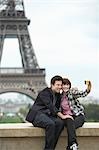 France, Paris, couple taking self portrait  in front of Eiffel Tower