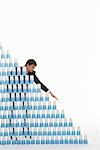Man stacking plastic cups into a pyramid against white background