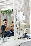Homme d'affaires lisant le journal dans le salon de coiffure