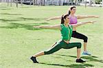 Zwei Frauen tun Yoga im Park