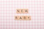 Game tile letters spelling new baby