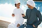 Two Middle Eastern men with mobile phones