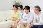 Japanese Family Relaxing On Sofa