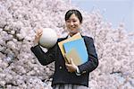 Schoolgirl Holding Books and Volleyball