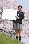 Schoolgirl Standing in Park Holding Whiteboard