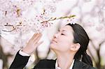 Woman Smelling  Flowers in Park