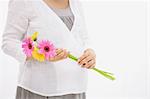 Ventre de femme enceinte tenant des fleurs