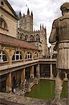 Statue at Roman Bathhouse, Bath Abbey in the Background, Bath, Somerset, England