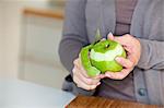 Woman peeling apple in kitchen, close-up