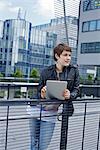 Young woman using iPad in front of an office building