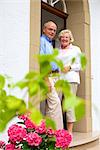 Happy senior couple at the front door