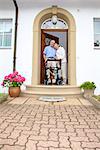 Senior couple with walking frame at the front door