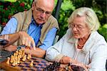 Altes Paar auf Terrasse spielt Schach